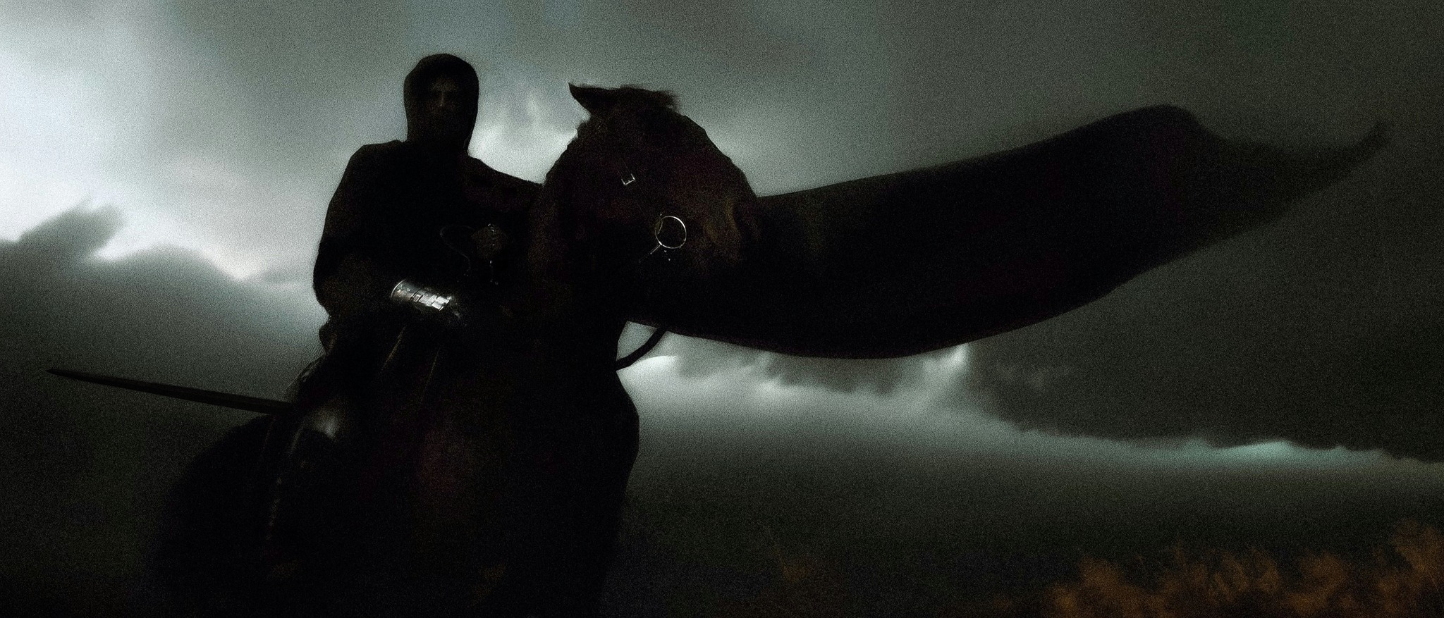 Dark rider on horse under a storm
